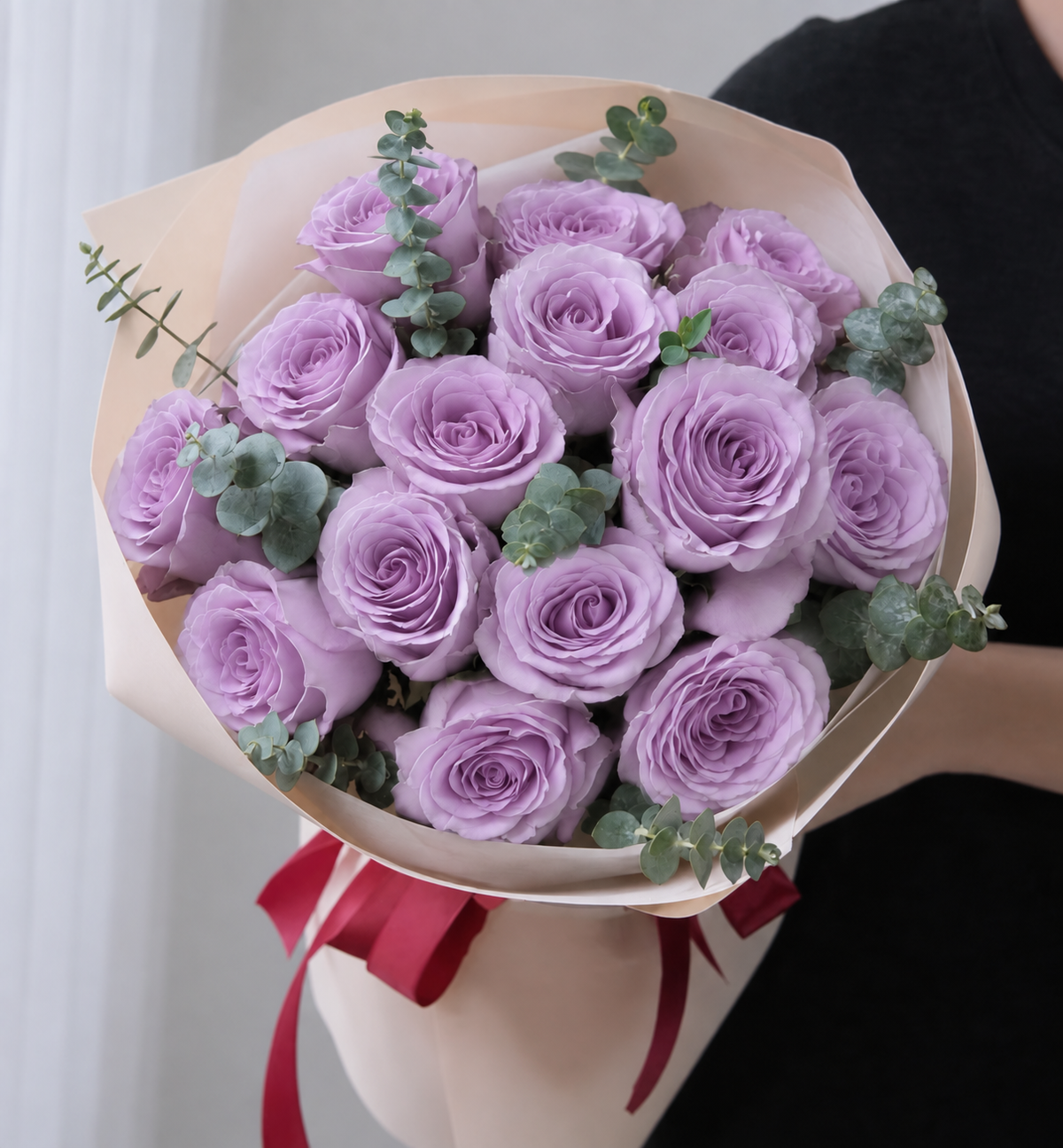Wrapped bouquet of lavender roses with eucalyptus